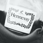 bottle of hennessy sitting in a black and white shoe