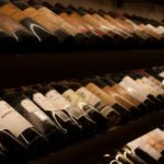 Close up of wine bottles on a rack in a wine cellar.