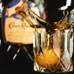 Close up of crown royal splashing out of a whiskey glass.